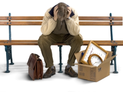 Businessman siting on a bench with his stuff packed in a box.